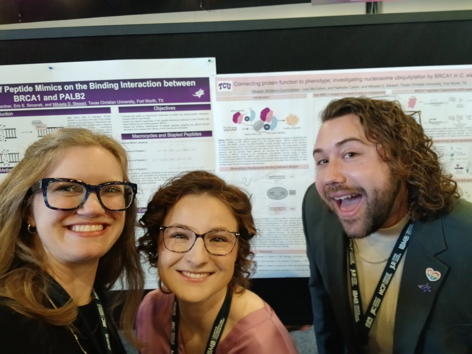 Lab members taking a selfie in front of conference posters