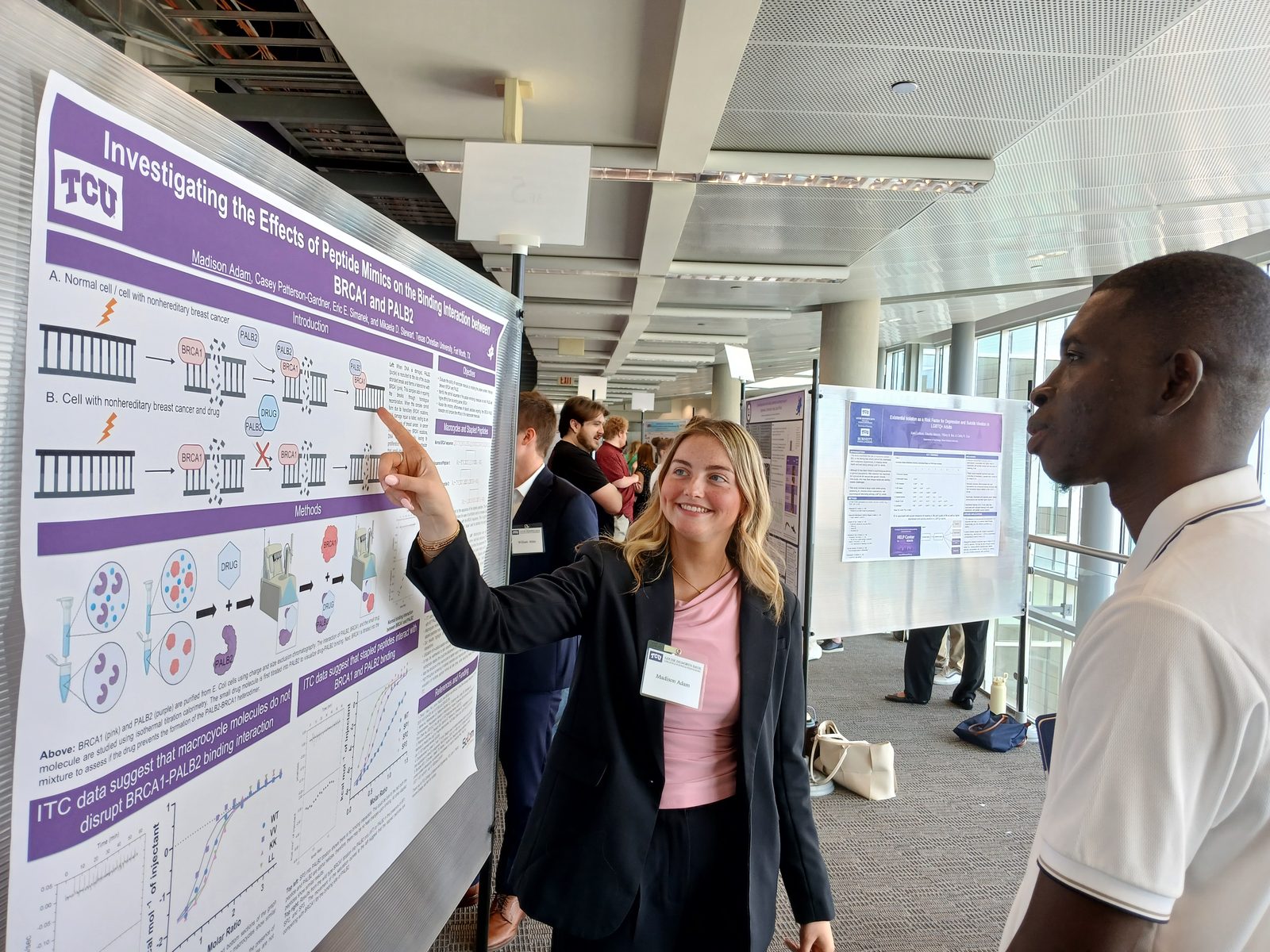 Student explaining a poster on peptide mimics of the BRCA1-PALB2 interaction