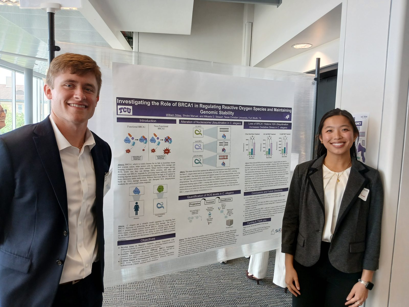 Two students with a poster on BRCA1 and reactive oxygen species